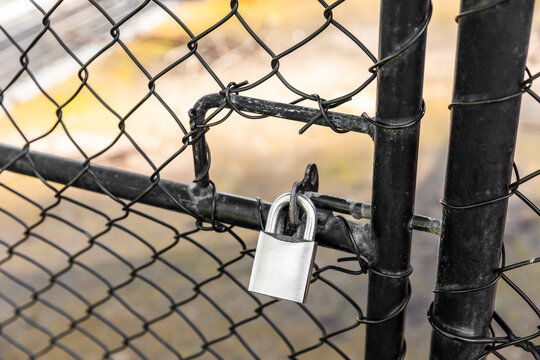 Rusty Padlock Attached to Caged Fence