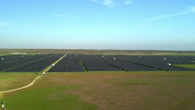 Pull back aerial view of solar farm in rural field outside major city