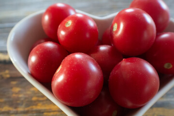 A dish filled with small, juicy, red cherry tomatoes