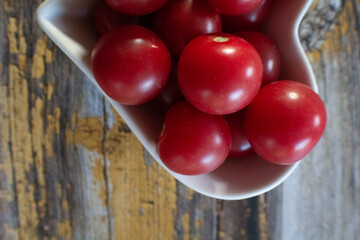 A dish filled with small, juicy, red cherry tomatoes