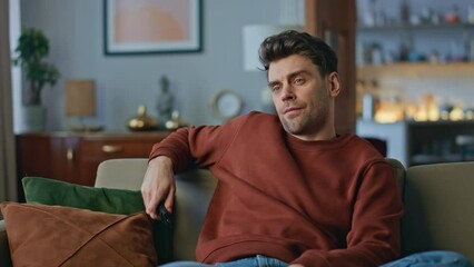 Bored hipster choosing movie chilling at couch close up. Man switching channels