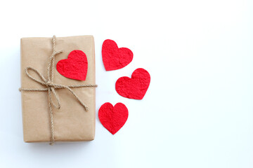Brown gift box and red paper heart on white background