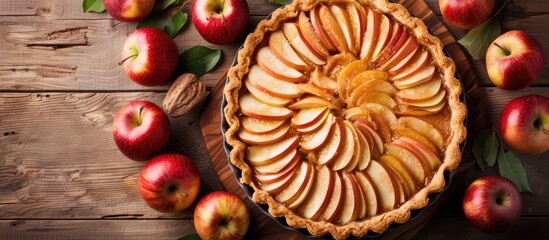 A freshly baked apple pie sits on a rustic wooden table, adorned with perfectly sliced apples. The golden crust glistens, promising a flavorful and applelicious treat.
