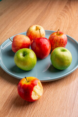 delicious apples on a wooden table, bitten apple, red apple and green apple