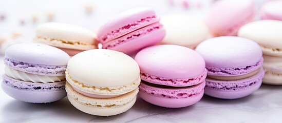 A row of assorted pastel-colored macaroons sits neatly lined up on top of a counter in delicate shades of white, purple, and pink. These sweet treats are perfect for any pastel-colored macaroons