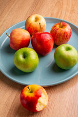 delicious apples on a wooden table, bitten apple, red apple and green apple