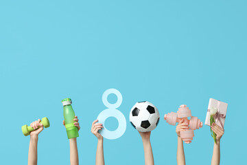 Female hands with paper figure 8, sports equipment and gift box for International Women's Day on color background