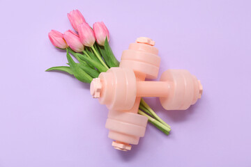 Pair of dumbbells and beautiful tulip flowers for International Women's Day on lilac background