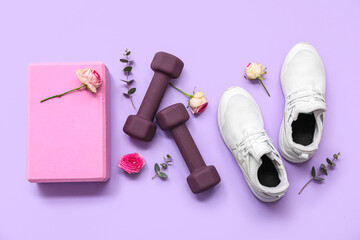 Composition with sports equipment, shoes and flowers on lilac background. International Women's Day