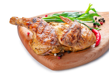 Half of a fried small chicken on a wooden board on a white background, close up