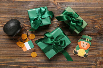 Gift boxes with gingerbread cookie and pot of golden coins for St. Patrick's Day celebration on wooden background