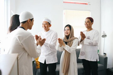 Group of young Asian muslim people forgiving each other by giving greet hands during Eid Mubarak...