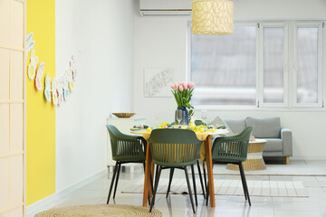 Interior of stylish dining room with festive Easter table setting