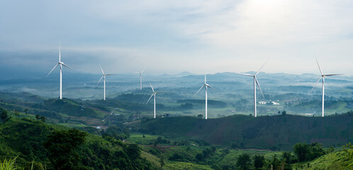 Landscape of Mountain and wind turbine farm with foggy valley and distant mountains on horizon. © banphote