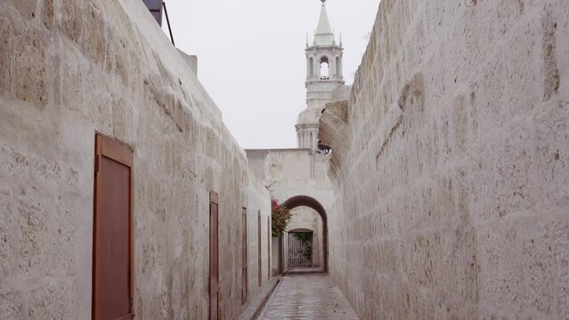 Old ashlar passageway with a view of one of the towers of the Cathedral of Arequipa.