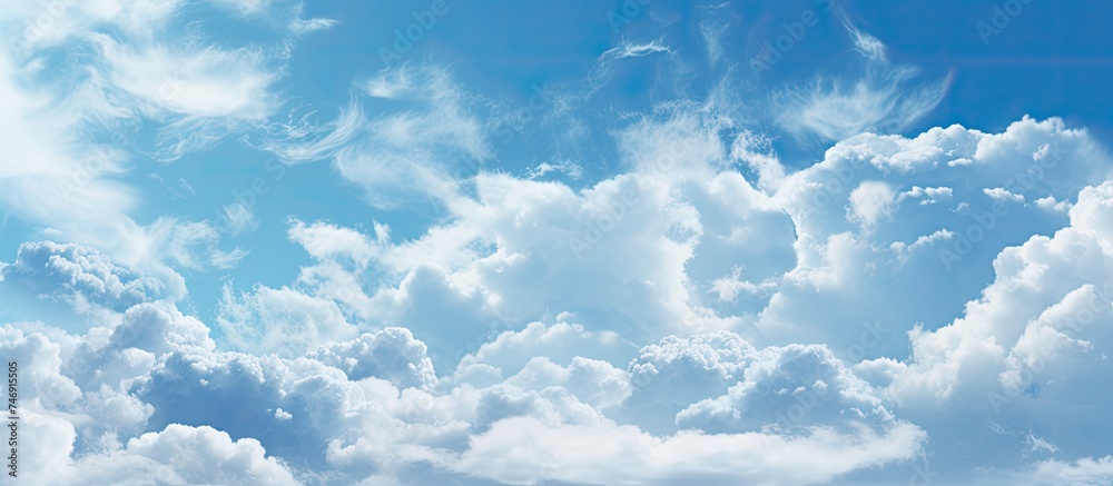 Poster A plane is flying through a cloudy blue sky, leaving a trail behind it. The clouds are thick and fluffy, creating a dynamic backdrop for the flying aircraft.