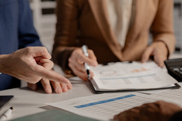 A group of businesspeople is discussing important documents to present to a capitalist, Colleagues are exchanging information with each other, Share information in the meeting room