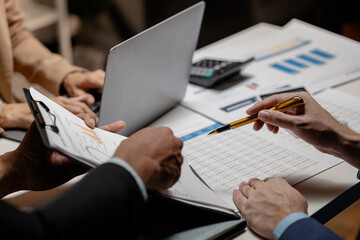 Three businesspeople are brainstorming together in a conference room about documents that need to be edited on the table, Colleagues are exchanging ideas about business strategies.