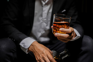 Closeup businessmen holding a glass of whiskey