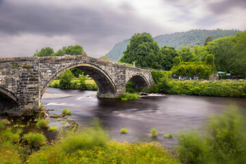 Historic steep stone arch bridge crossing a river - Pont Fawr (Inigo Jones Bridge) Llanrwst North Wales
