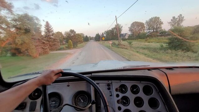 POV driving old dump truck down bumpy dirt road in rural America