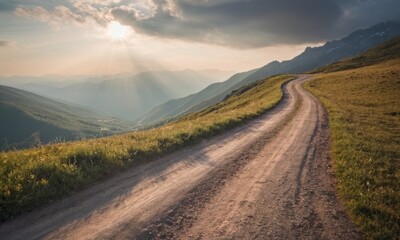 Fototapeta na wymiar Curved rural road in the mountains. Sun rays from clouds at sunset