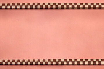 棒状に並べた赤と白のチェック柄のブロックが上下に並ぶアプリコットピンクのフレーム