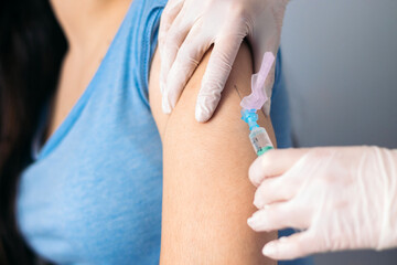 Vaccine in injection needle. Doctor working with patient's arm. Physician or nurse giving vaccination and immunity to virus, influenza or HPV with syringe. Appointment with medical expert. Close-up - obrazy, fototapety, plakaty