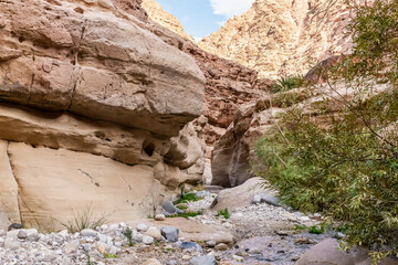 Bizarre grandeur of mountains in the path of the shallow stream in the gorge Wadi Al Ghuwayr or An Nakhil and the wadi Al Dathneh near Amman in Jordan