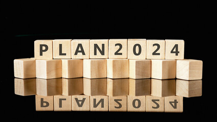 PLAN 2024 on wooden cubes on a glossy black background