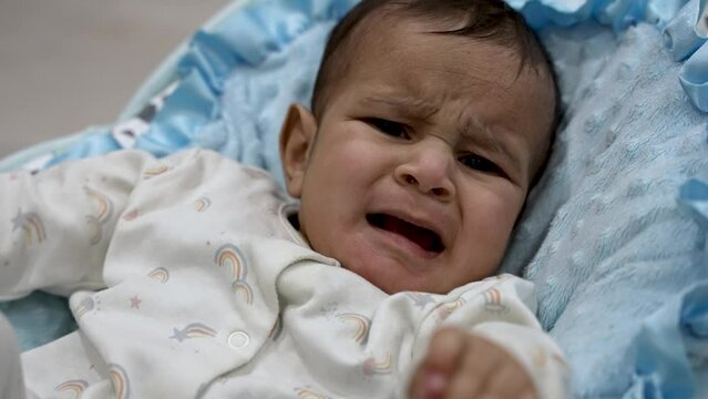Distressed six month old Asian Indian baby expresses attention with crying MEDIUM SHOT