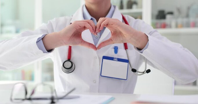 Doctor therapist cardiologist forms heart shape with hands