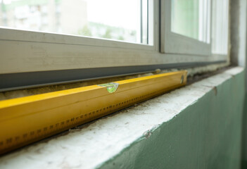 Yellow Spirit Level Balanced on a Window Ledge During Daytime Construction Work