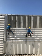 Abseiling from a tall building using a rope.