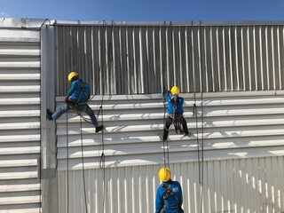Abseiling from a tall building using a rope.