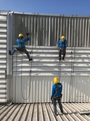 Abseiling from a tall building using a rope.