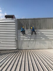 Abseiling from a tall building using a rope.