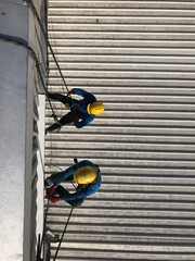 Abseiling from a tall building using a rope.