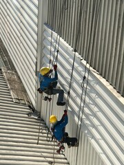 Abseiling from a tall building using a rope.