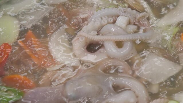 전골 냄비에 낚지와 야채가 담긴 연포탕이 끓고 있는 클로즈업 패닝 영상 
