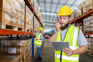 Male holding walkie talkie and tablet quality control standing at machine of factory warehouse....