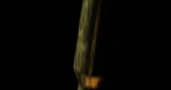 Blurred motion of a 6mm ARC bullet casing falling against a black background, slow motion