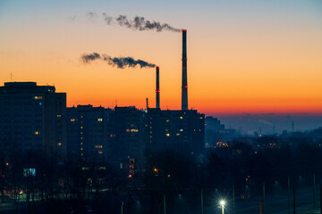 View across the Poland City of Tychy with two chimneys with a sunrise background