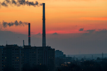 Naklejka premium View across the Poland City of Tychy with two chimneys with a sunrise background