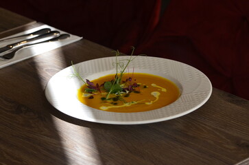 yellow cream soup , with pumpkin seeds, background of delicious healthy food for vegetarians , served food in restaurant