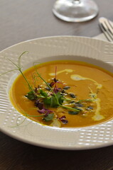 pumpkin soup, served in a restaurant, decorated with herbs