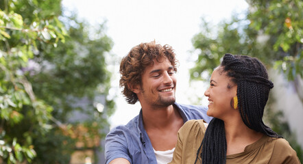 Fototapeta premium Interracial, couple and smile together in nature, happy and love in diversity people with tree in backyard. Happiness, affection or staring, outdoor for relationship growth or commitment for romance