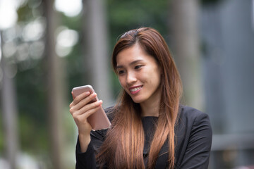 Asian businesswoman using her smart phone.