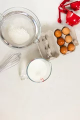 Foto op Aluminium Ingredients for baking are neatly arranged on a white surface with copy space © wavebreak3