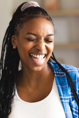Young African American woman laughs joyfully, sticking out her tongue playfully